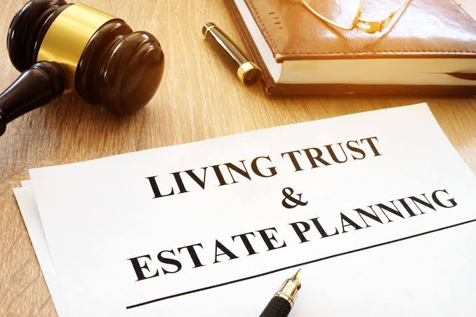 Living trust and estate planning documents on a wooden desk beside a gavel
